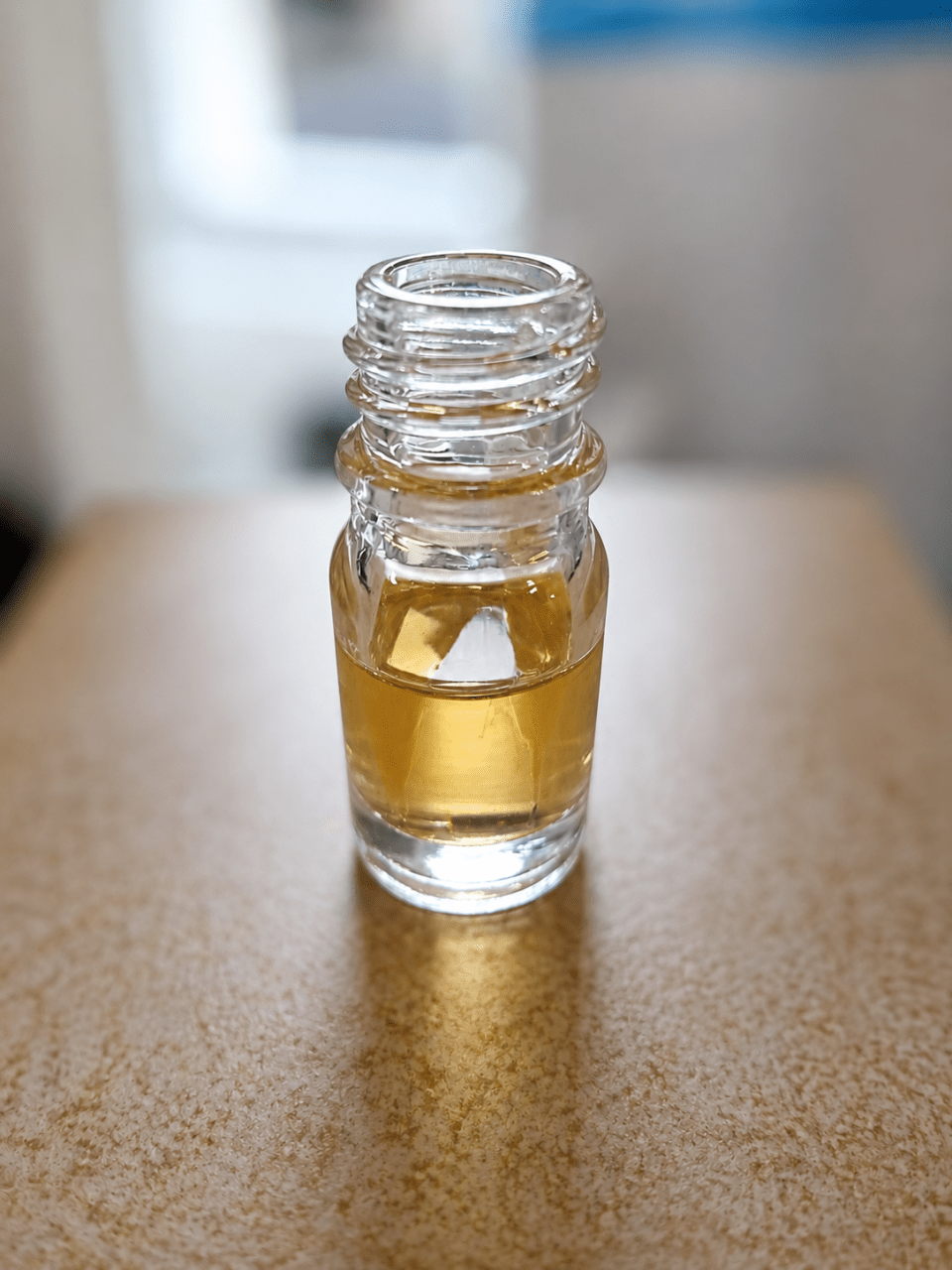 Small glass bottle with a yellow liquid on a countertop